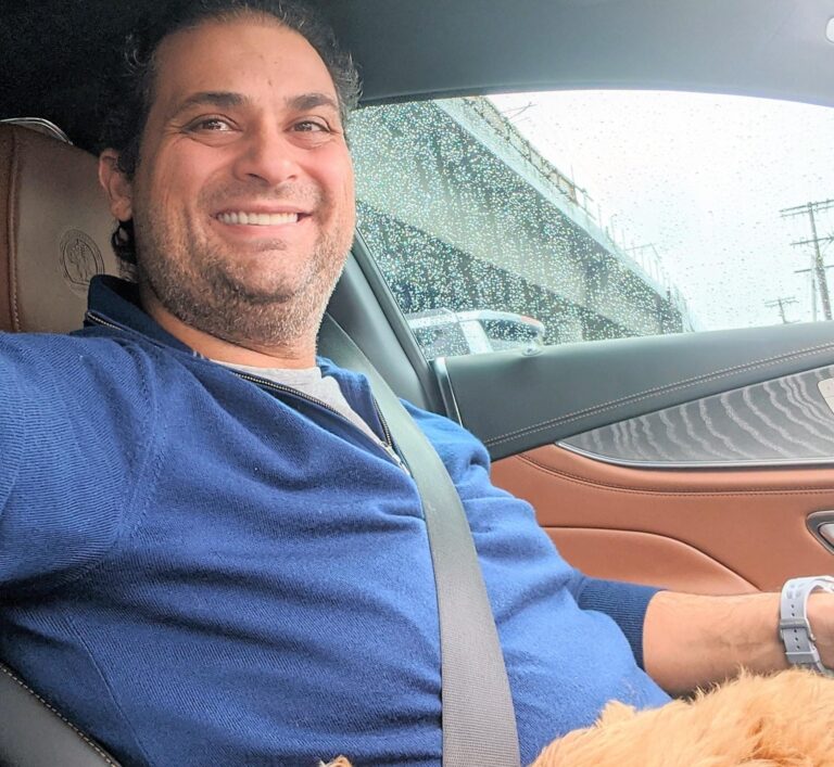 Dr. Navid Vahedi sitting in his car, smiling.